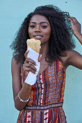 Porträt einer lächelnden jungen Frau, die Eiscreme genießt - VEGF00777