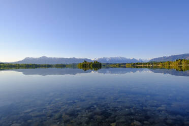 Deutschland, Bayern, Uffing am Staffelsee, Blick auf den Staffelsee, in dem sich der klare Himmel und die umliegenden Berge spiegeln - SIEF09202