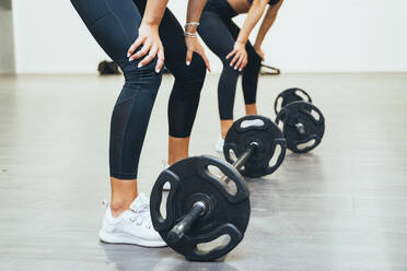 Two women exercising with weights in a gym - JCMF00258