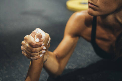 Zwei Frauen in guter Form tun Arm Wrestling Herausforderung in einer Turnhalle - JCMF00272