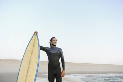 Surfer am Strand stehend bei Sonnenuntergang - AHSF01065