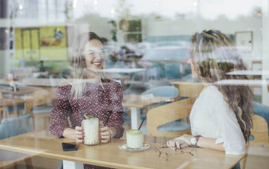 Freunde in einem Café, durch ein Fenster gesehen - MOMF00771