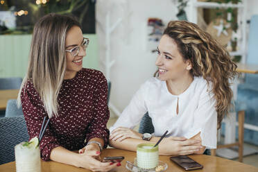 Freunde mit Smartphones in einem Cafe - MOMF00774