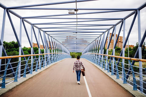 Zigeunerjunge mit Gitarre geht über die Brücke, lizenzfreies Stockfoto