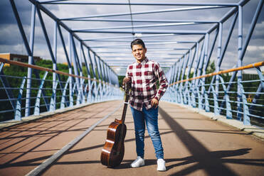 Zigeunerjunge mit Gitarre auf einer Brücke - OCMF00835