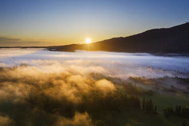 Germany, Upper Bavaria, Gaissach, Aerial view of fog above landscape at sunrise - SIEF09203