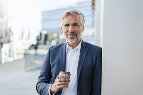 Porträt eines reifen Geschäftsmannes mit Kaffee zum Mitnehmen in der Stadt, lizenzfreies Stockfoto