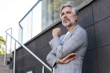 Fashionable mature businessman standing on stairs - DIGF08574