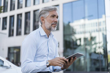 Mature businessman using tablet in the city - DIGF08586