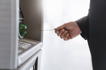 Close-up of businessman withdrawing money at an ATM - DIGF08599