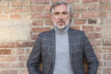 Portrait of businessman wearing blue suit and grey turtleneck pullover  stock photo