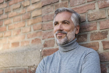 Portrait of mature businessman at a brick wall - DIGF08628