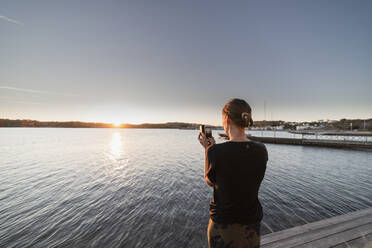 Woman photographing sunset - JOHF04388
