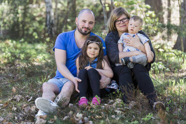 Vierköpfige Familie schaut in die Kamera - JOHF04403