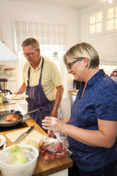 Älteres Paar bei der Zubereitung einer Mahlzeit in der Küche - JOHF04456