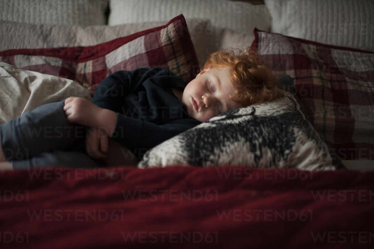 https://us.images.westend61.de/0001276782pw/toddler-boy-1-2-years-old-asleep-on-pillows-in-bed-with-red-bedding-CAVF65909.jpg