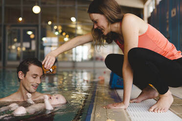 Parents with baby in swimming-pool - JOHF04546