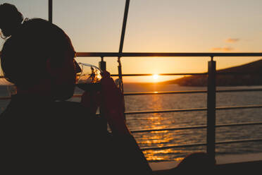 Woman having drink at sea - JOHF04600