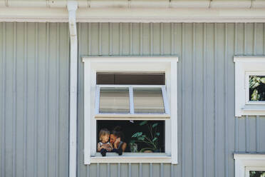 Mother with daughter seen through window - JOHF04632