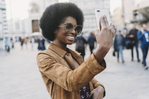 Junge Frau mit Afro-Haar nimmt Selfie in der Stadt - CUF52560
