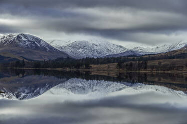 Reflection of snow capped mountains in lake, Scottish Borders, United Kingdom - CUF52659