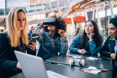 Freunde arbeiten an einem Virtual-Reality-Projekt in einem Straßencafé, Mailand, Italien - CUF52752