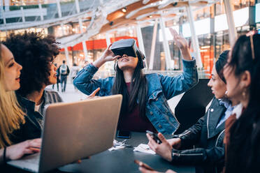 Freunde arbeiten an einem Virtual-Reality-Projekt in einem Straßencafé, Mailand, Italien - CUF52755