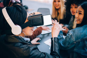 Freunde arbeiten an einem Virtual-Reality-Projekt in einem Straßencafé, Mailand, Italien - CUF52757