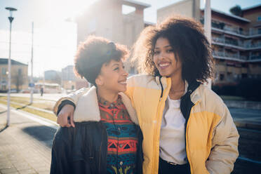 Zwei coole junge Freundinnen auf einem sonnenbeschienenen städtischen Bürgersteig, Porträt - CUF52788