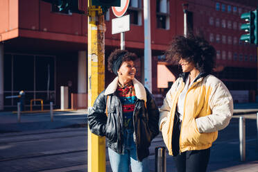 Two cool young female friends chatting in urban street - CUF52803