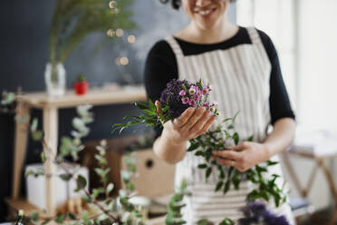 Nahaufnahme einer Frau mit Blumen in einem kleinen Laden - HAPF03027