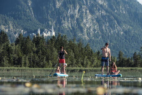 Familie beim Paddeln auf dem Bannwaldsee, Schloss Neuschwanstein im Hintergrund, Füssen, Deutschland - WFF00120