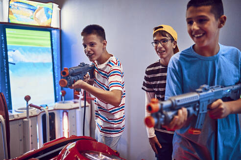Freunde im Teenageralter schießen in einer Spielhalle mit Gewehren - ZEDF02660