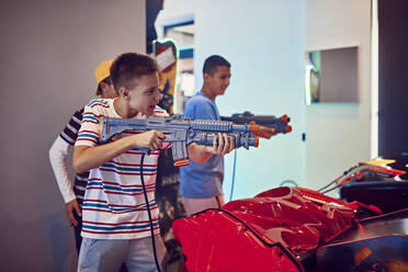 Freunde im Teenageralter schießen in einer Spielhalle mit Gewehren - ZEDF02662