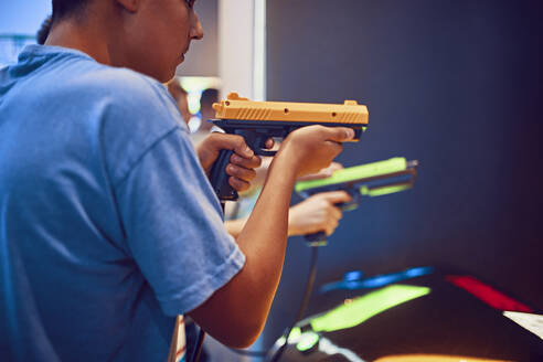 Teenager-Freunde schießen mit Pistolen in einer Spielhalle - ZEDF02663