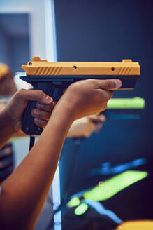 Hand eines Teenagers, der mit einer Pistole in einer Spielhalle schießt - ZEDF02664