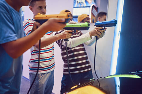 Teenager-Freunde schießen mit Pistolen in einer Spielhalle - ZEDF02666