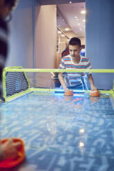 Jugendlicher spielt Airhockey in einer Spielhalle - ZEDF02678