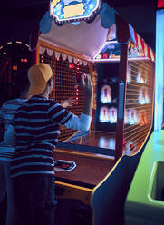 Freunde im Teenageralter werfen Bälle auf einen Spielautomaten in einer Spielhalle - ZEDF02681