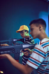 Freunde im Teenageralter schießen in einer Spielhalle mit Gewehren - ZEDF02692