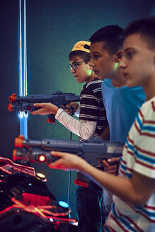 Freunde im Teenageralter schießen in einer Spielhalle mit Gewehren - ZEDF02694