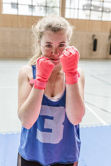 Porträt einer selbstbewussten Boxerin in einer Sporthalle - STBF00474