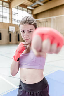Porträt einer selbstbewussten Boxerin in einer Sporthalle - STBF00476