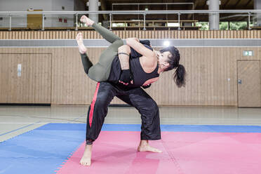 Kickboxerin beim Training mit Trainer in der Sporthalle - STBF00482