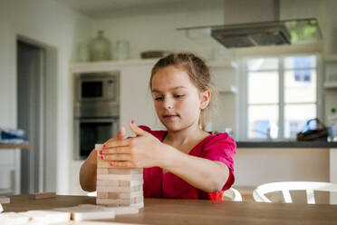 Portrait of girl playing on table at home - EGBF00374