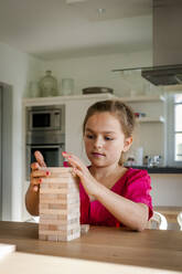 Portrait of girl playing on table at home - EGBF00375