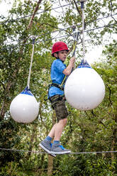 Junge auf einem Hochseilgarten im Wald - EGBF00405