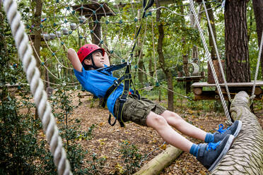 Relaxed boy on a rope course in forest - EGBF00407