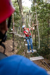 Frau auf einem Hochseilgarten im Wald - EGBF00413