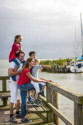 Familie steht auf einer Seebrücke und schaut auf die Aussicht, Ahrenshoop, Mecklenburg-Vorpommern, Deutschland - EGBF00425